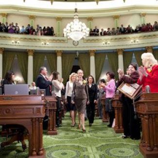 Secretary of State Debra Bowen approaches the dais to give her keynote address for the Woman of the Year ceremony.