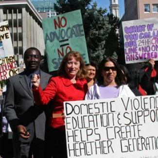 Senate Majority Leader Ellen Corbett (in red) rallies with advocates for domestic violence shelters and edudation programs.